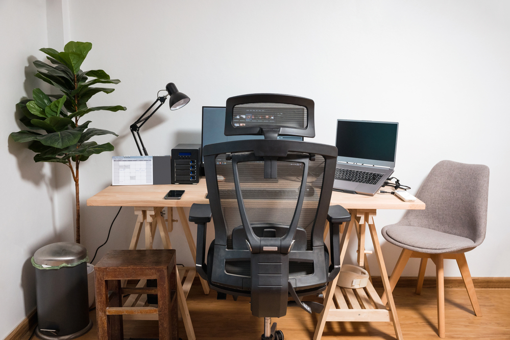 Imagem ilustra melhor cadeira ergonômica em frente a uma mesa de escritório